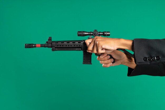 Closeup of a hand cocking a gun on a green background