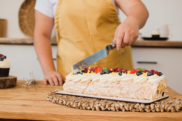 Closeup of a hand cutting a cake