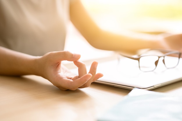 Closeup hand doing yoga concentration relax calm peace for reduce stress increase productivity at work