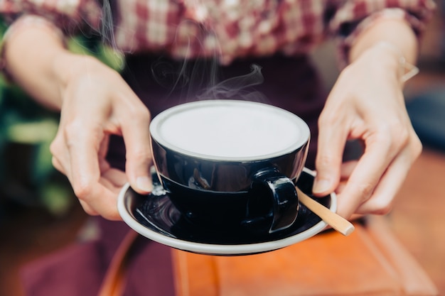 La bevanda della mano del primo piano serve la bevanda sana cremosa bianca calda del latte per ogni giorno