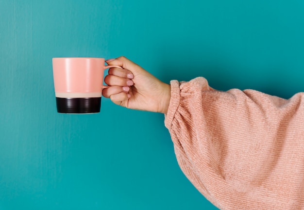 Photo closeup of hand holding coffee cup