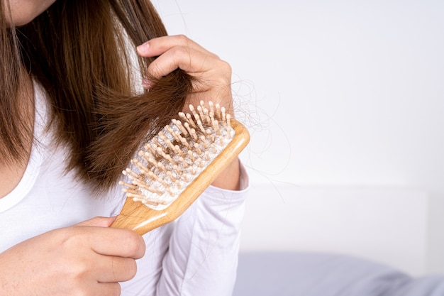 Closeup hand holding comb and hair fall problem.