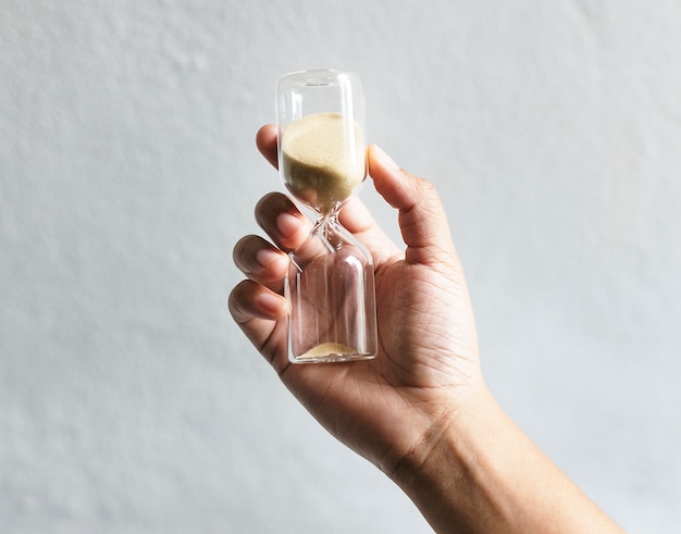 Closeup of hand holding hourglass