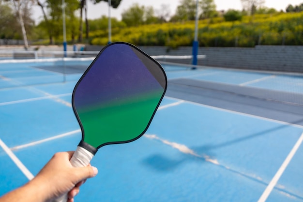 Photo closeup of a hand holding pickleball racket