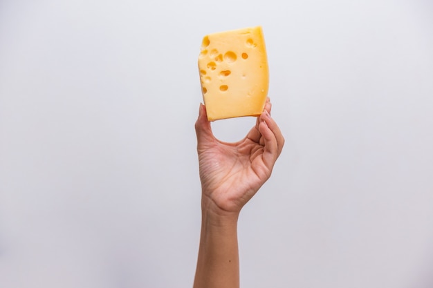 Closeup of hand holding a piece of elemental cheese.