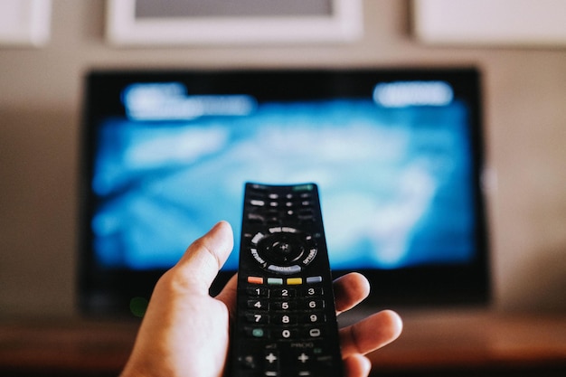 Closeup of the hand holding the remote control