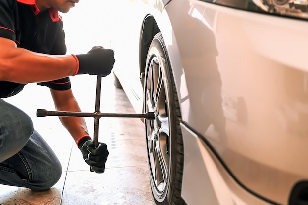 Closeup hand mechanic using wrench change tire