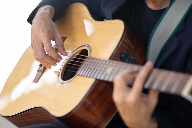 Foto mano del primo piano che suona il tempo della musica della chitarra