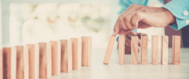 La mano del primo piano impedisce che il blocco di legno cada