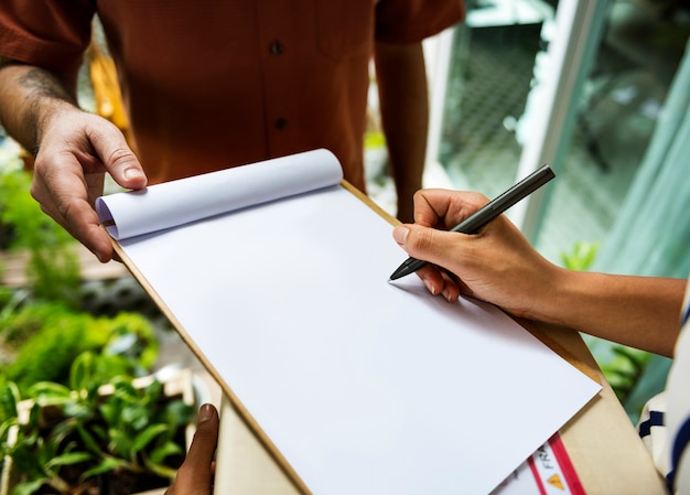 Closeup of hand signing on blank paper