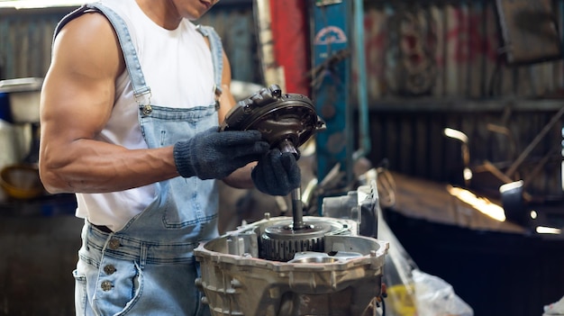 Photo closeup hand and spanner big muscle car engine mechanic fixing repair car gear in car service garage