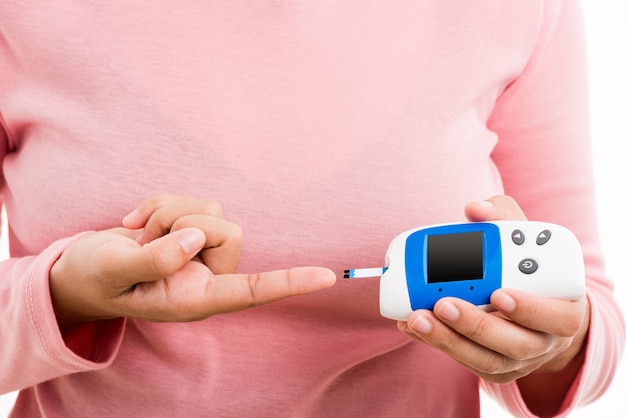 Closeup hand vrouw meten glucose test niveau controleren op vinger door glucometer