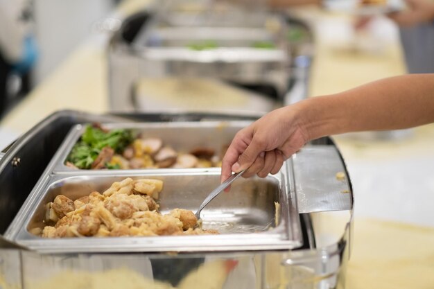 Closeup hand wearing gloves scooping food, catering, dinner time, prevent Coronavirus disease (covid 19)