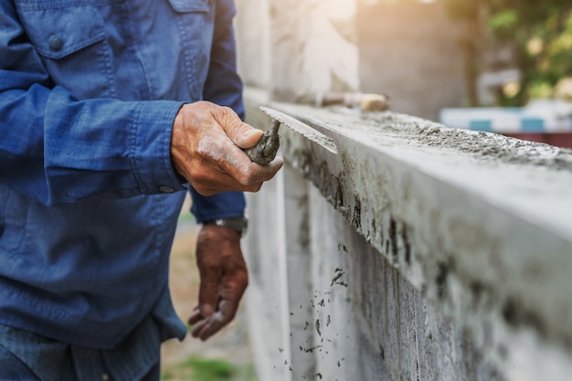 Photo closeup hand of worker are plastering