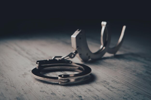 Closeup of handcuffs on obscure stainless steel