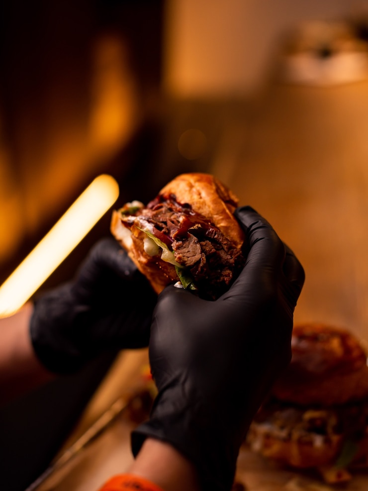 Foto closeup handen met lekker gegrild rundvlees burgervrienden eten bij fast food in cafebeer pubbar food