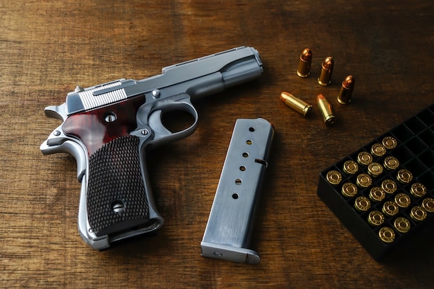 CloseUp handgun with golden sharp bullets on a black surface