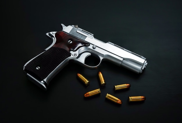 CloseUp handgun with golden sharp bullets on a black surface