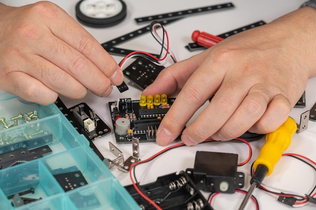 Близкий кадр рук, собирающих учебную игрушку для робототехники Концепция STEM-образования