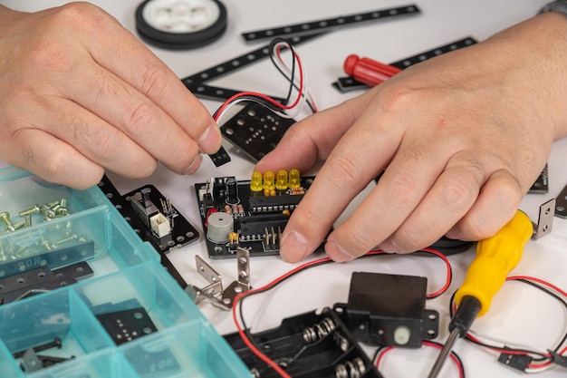 Foto closeup di mani che assemblano giocattoli educativi di robotica concetto di istruzione stem