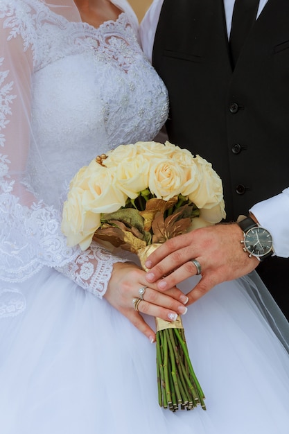自然の背景に結婚指輪と手ブライダルカップルのクローズアップ