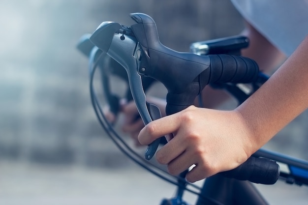 closeup hands and handlebar of a young biker on street 