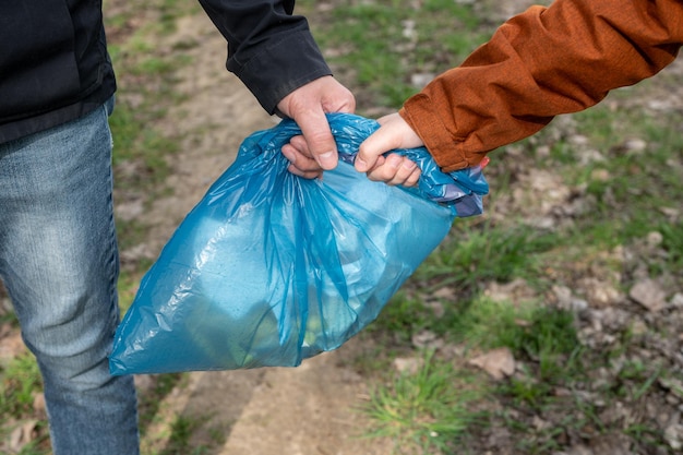 Closeup of Hands Holding Blue Garbage Bag