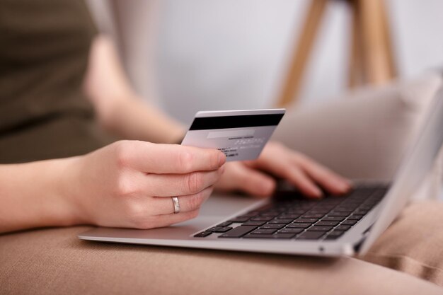 Closeup of hands holding card with laptop