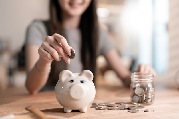 コインのガラスのポットを握っている手のクローズアップ 銀行の金融貯蓄と投資コンセプト
