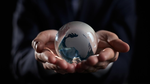 Closeup of hands holding world sphere in brown