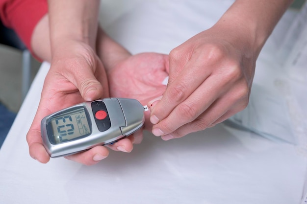 Closeup on the hands of a latin woman doctor doing a test to measure sugar levels