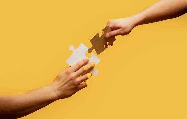 Closeup hands of man connecting jigsaw puzzle. Business solutions, success and strategy concept