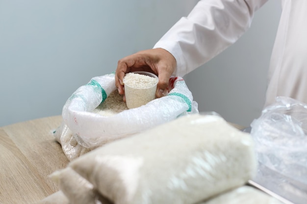 Photo closeup hands measuring rice for zakat small business concept