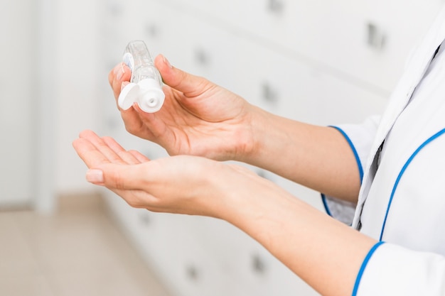 closeup hands of a medical worker or pharmacist using disinfectant, hand sanitizer in hospital