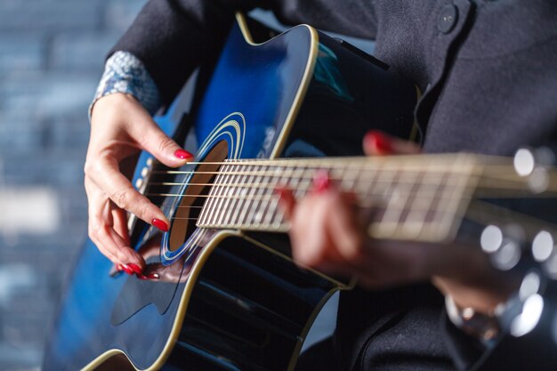 アコースティックギターを演奏するミュージシャンの手のクローズアップ
