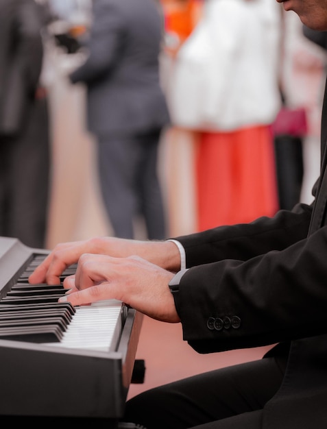 Closeup of the hands of a pianist playing during the celebration of an outdoor event