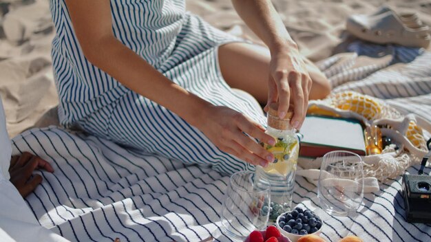 Closeup hands preparing picnic in sunlight relaxed girl pour water into glass