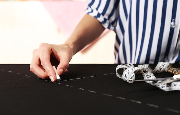 Foto primo piano le mani della sarta al lavoro con tessuto di stoffa