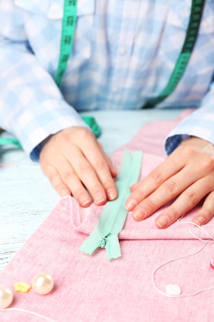 Foto primo piano le mani della sarta al lavoro con tessuto di stoffa