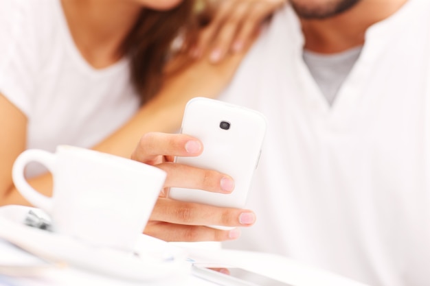 A closeup of hands and smartphone in a cafe