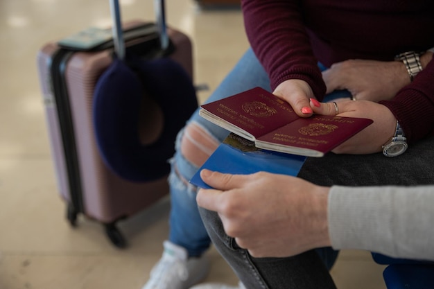 Closeup of the hands of a traveler couple holding a map and their passports