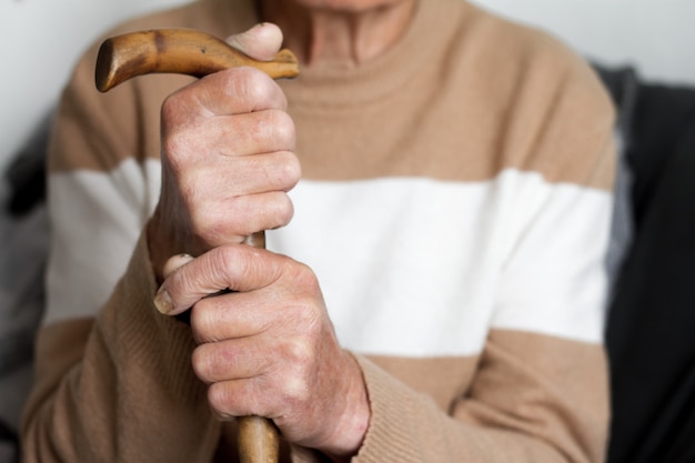 ベージュ色のセーター健康概念の中で非常に高齢者の手のクローズアップ