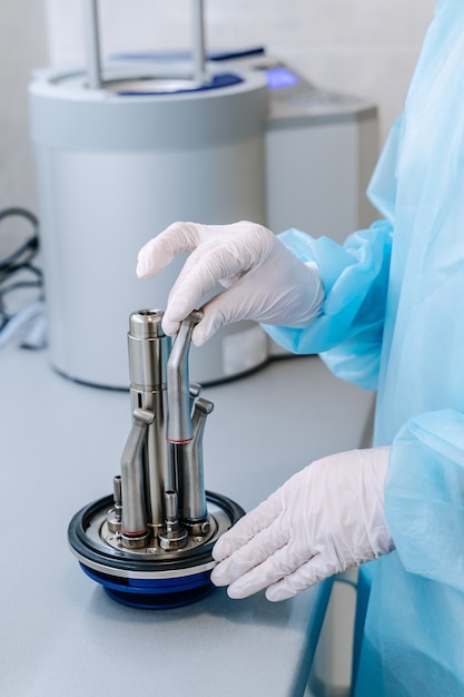 Closeup hands with gloves in the places medical autoclave for sterilising surgical and dental instruments.