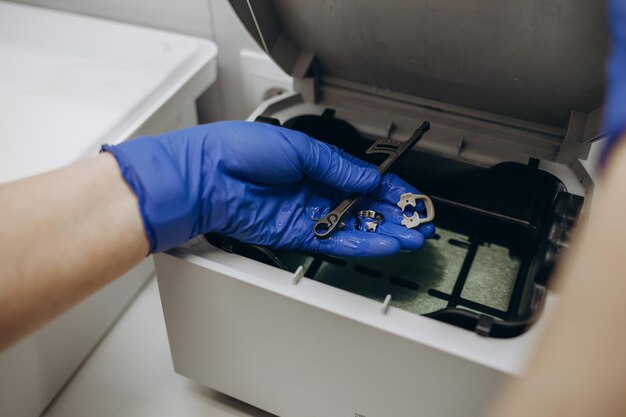 Closeup hands with gloves in the places medical autoclave for sterilising surgical