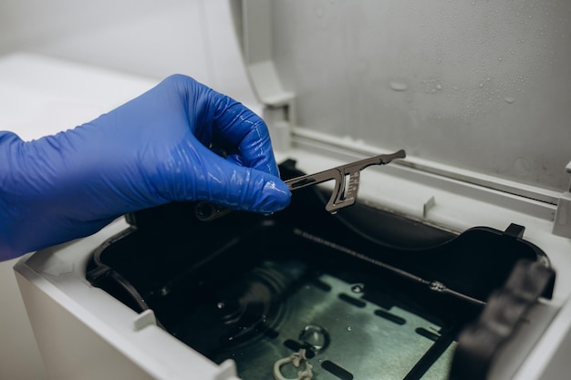 Closeup hands with gloves in the places medical autoclave for sterilising surgical