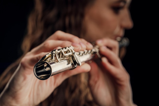 Closeup of the hands of a woman playing the flute musical\
concept