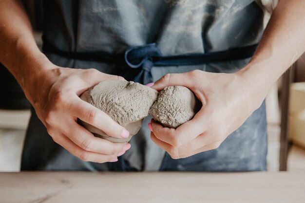 Closeup on hands of young master with large pieces of clay