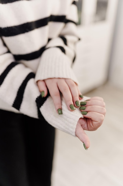 Photo closeup of the hands of a young woman receiving the nail file by a beautician at the beauty salon