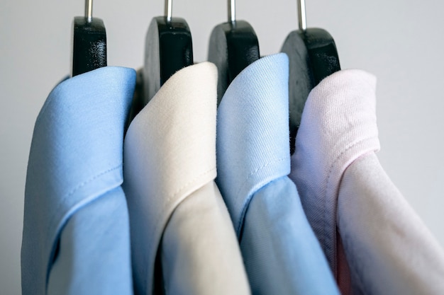 Крупным планом вешалки с деловыми рубашками Ряд цветных рубашек на стойке