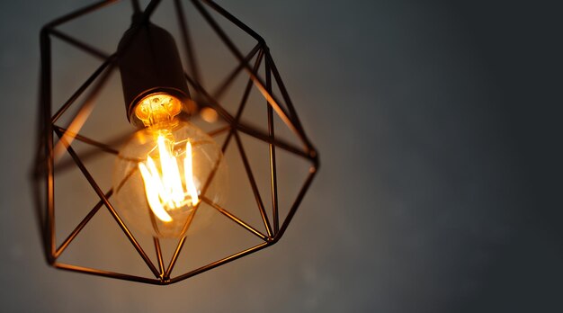 Closeup of hanging lamp glowing with warm light on dark background Good idea